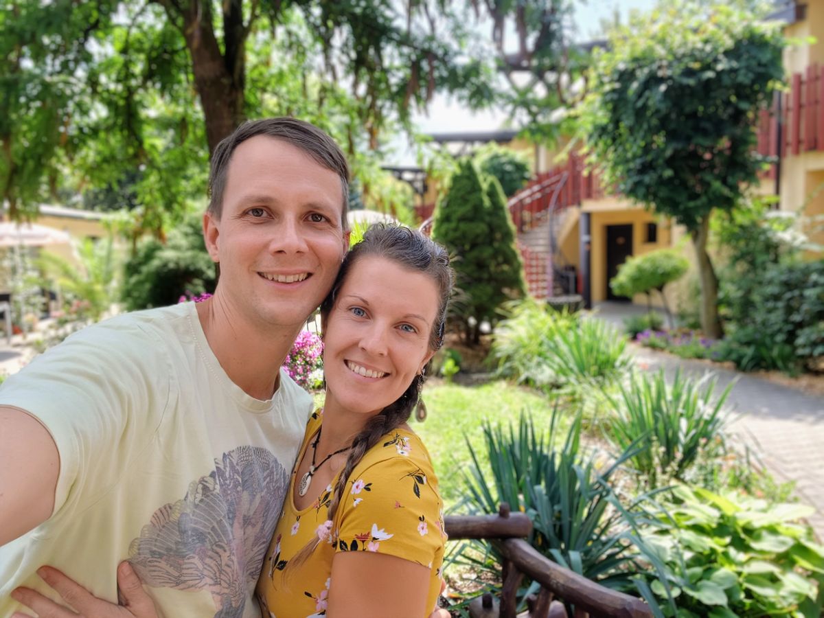 Jiří Vitek a Petra Vitková Martochová se usmívají na zahradě plné zeleně.
